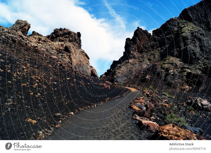 Volcanic pathway of stone mountains in bright day road volcanic mineral black travel landscape sky nature rural empty journey scenery destination touristic