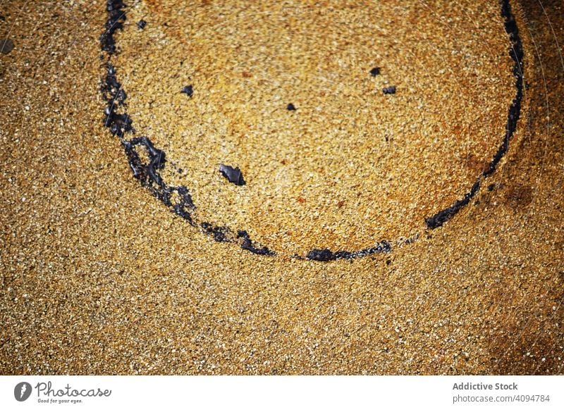 Wet sand texture with circle trace wet surface pollution concept oil round imprint dark drop spot old rusty coast nature coastline shore material beach rough