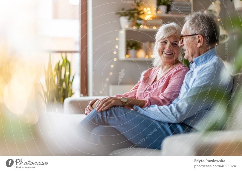 Portrait of a senior couple relaxing at home people woman adult mature casual attractive female smiling happy Caucasian toothy enjoying two people love