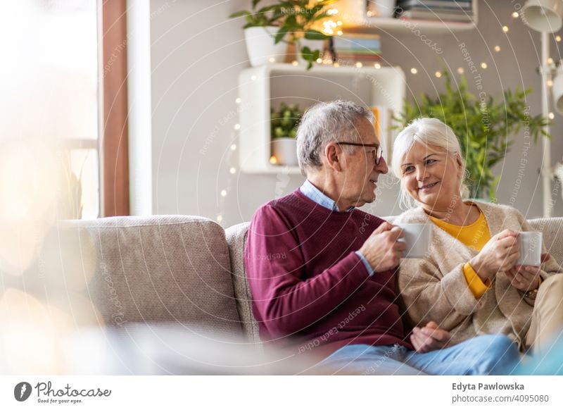 Portrait of a senior couple relaxing at home people woman adult mature casual attractive female smiling happy Caucasian toothy enjoying two people love