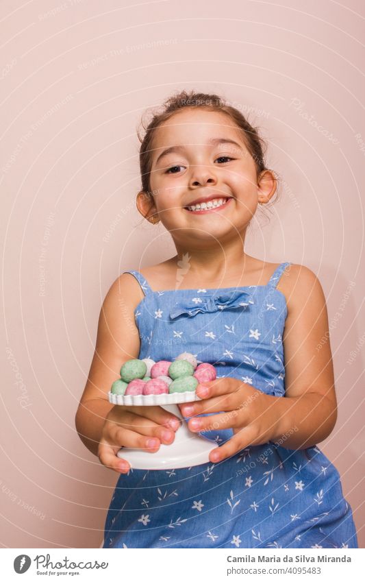 Happy child holding plate with mini chocolate eggs. april candy celebration childhood colorful copy space decoration dessert easter festive food fun happy
