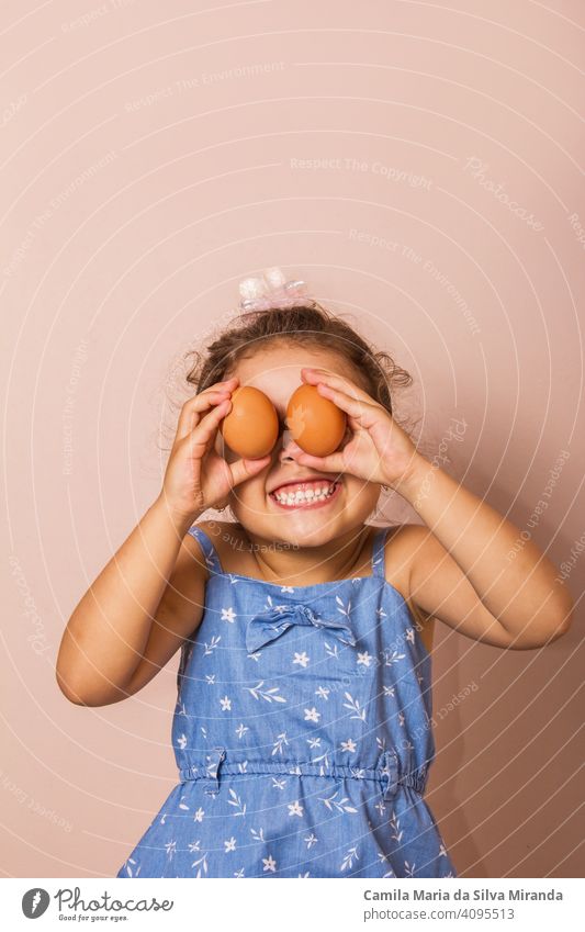 Smiling child holding two eggs. background beautiful bunny caucasian celebrate celebration colorful copy space cute ears easter fun funny girl happy holiday joy