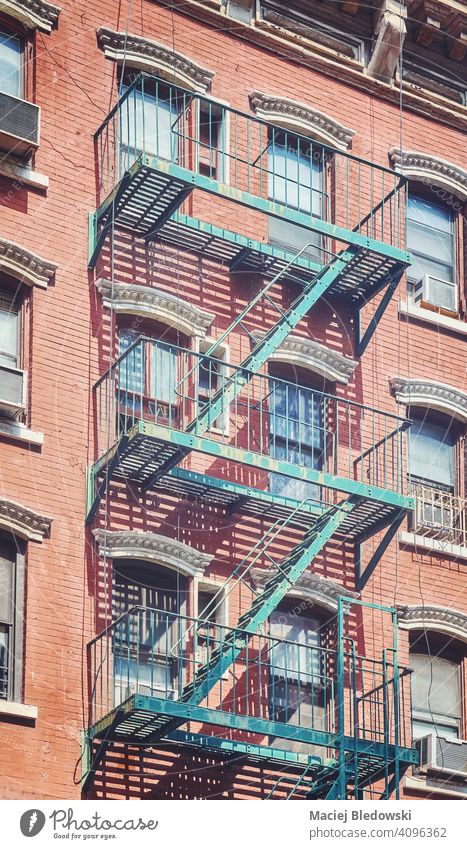 Old brick building with iron fire escape, color toning applied, New York City, USA. city Manhattan old townhouse architecture stairs apartment facade NYC ladder
