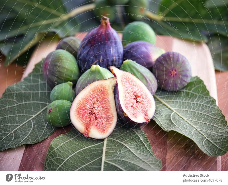 chopped fig and figs over wooden table with green leaves leaf mature rustic fresh fruits rural tree food traditional closeup spain home edible ripe bright