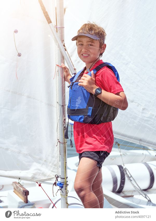 Boy in blue life jacket on yacht going to swim boy swimming cruising water safety shore waves ocean swimwear child tense training health learning holding
