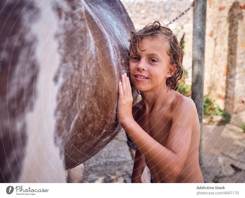 Delighted boy fondling stallion horse embrace love ranch harmony happy delighted kid hair care curly wet side child countryside horseback cheerful hobby