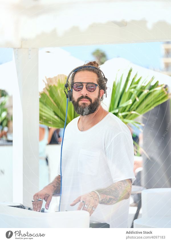DJ playing music at party man dj headphones fun controller set turntable mix song gig concert electronic event summer leisure job hobby male handsome hipster