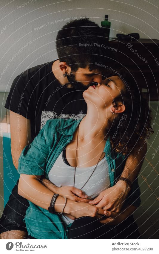 Sensual hipster couple kissing and cuddling at home cuddle embracing sensual affectionate casual rest room modern relationship romance smile love together happy