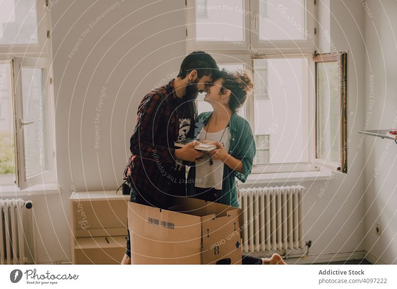 Casual couple unpacking boxes in apartment casual hipster together barefoot room light domestic home house cardboard new carton relocation estate package