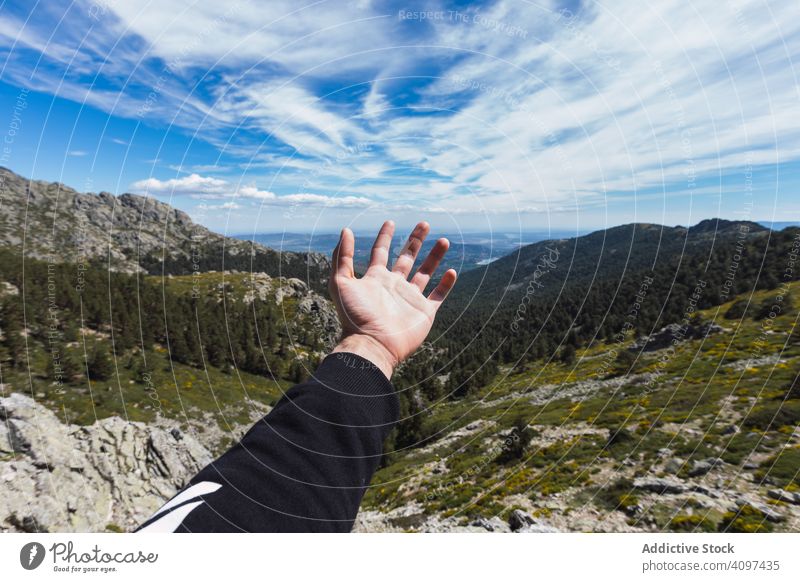 Person stretching hand to blue sky above mountain valley nature travel park forest landscape scenic hill rocky rural green scenery beautiful serenity peaceful