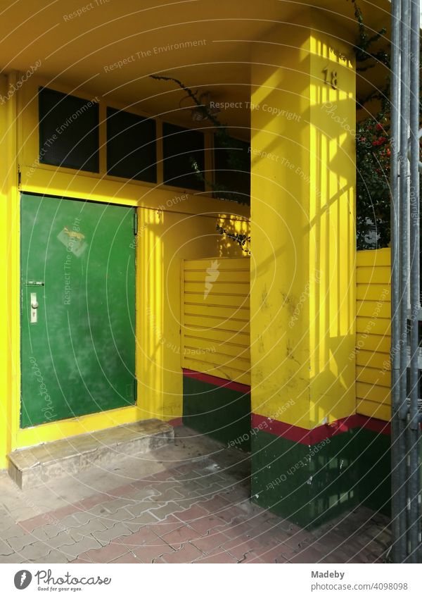 Notausgang mit grüner Stahltür eines mexikanischen Restaurant mit gelber Fassade im Stadtteil Bockenheim in Frankfurt am Main in Hessen Tür Feuerschutz Gelb