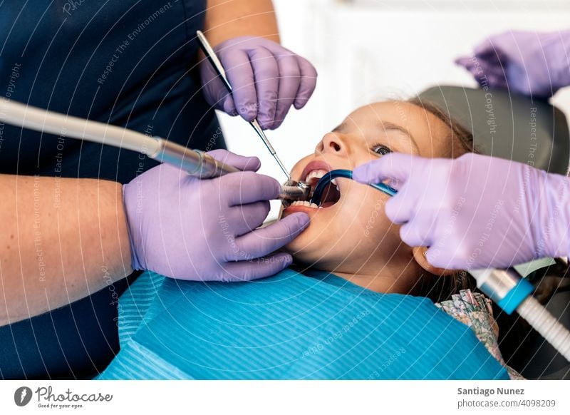Young Girl During Checkup in Dentist cleaning dental tools examining front view kid girl young looking up dentist clinic dental clinic patient lying health care