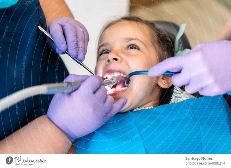 Young Girl In Dentist With Open Mouth closeup cleaning dental tools examining front view kid girl young looking up dentist clinic dental clinic patient lying