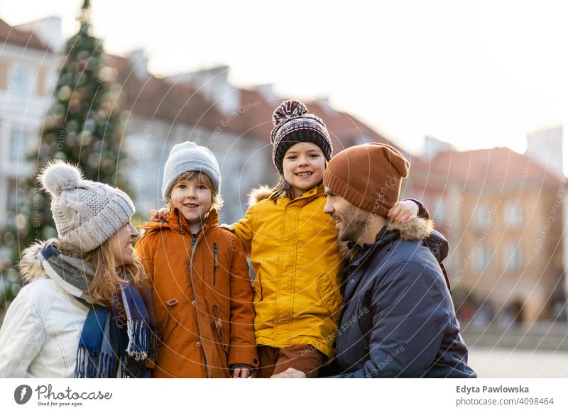Happy young family having fun outdoors during Christmas winter man autumn father woman mother parents relatives son boys kids children relationship together