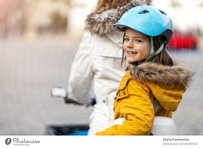 Young woman and her son riding the bicycle in a city young wearing bike helmet cycling winter autumn mother family parents relatives boy kid children