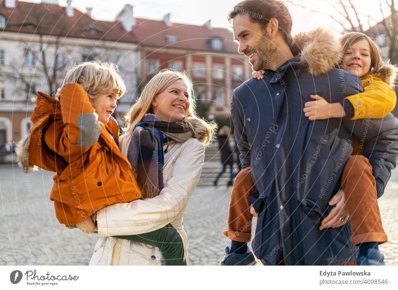 Young family with two children in a city young winter man autumn father woman mother parents relatives son boys kids relationship together togetherness love