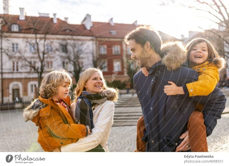 Young family with two children in a city young winter man autumn father woman mother parents relatives son boys kids relationship together togetherness love