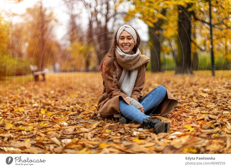 Portrait of smiling young woman in a park in autumn nature leaves freedom healthy trees yellow forest season public park relax serene tranquil fall outdoors