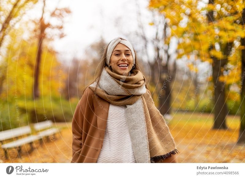 Portrait of smiling young woman in a park in autumn nature leaves freedom healthy trees yellow forest season public park relax serene tranquil fall outdoors