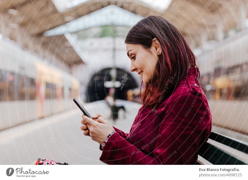 close up of beautiful caucasian woman in train station ready to travel using mobile phone. Travel and lifestyle concept technology smart phone internet device