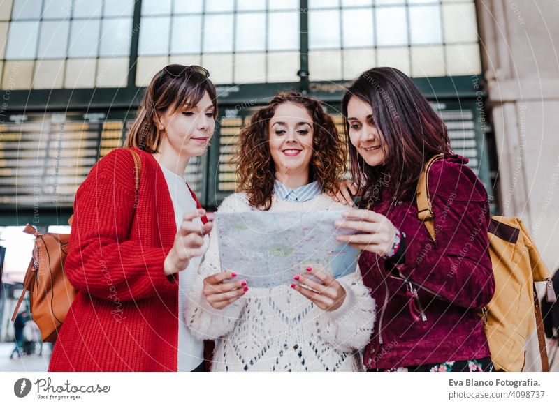 group of three young caucasian women at train station reading a map. Travel and friendship concept travel together fun 3 board backpacker city public transport