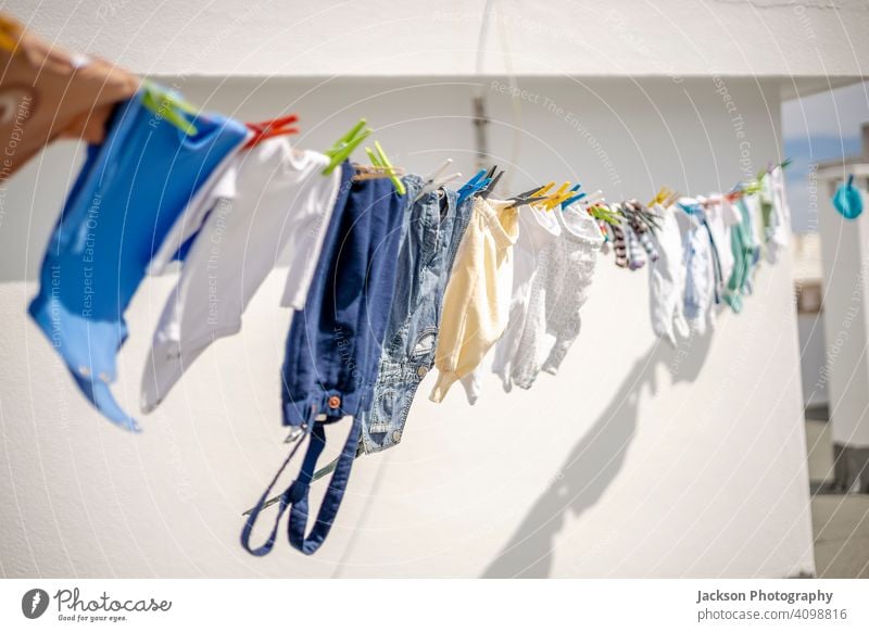 Drying a lot of baby clothes on the roof in the city dry laundry boy infant small body grow trousers cute kid pegs care cotton little fun clip child life