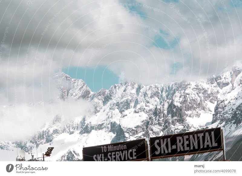 Out, over. Corona has pushed ski rental to the edge. Advertising boards in front of snow-covered Dachstein. Ski rental Rental skis Ski service Billboards