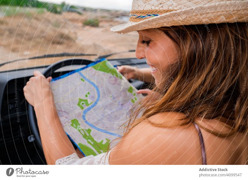 woman looking at a map inside a minivan car route front seat road tourism navigation transport vehicle concentration riding together traveler joyful pleasure