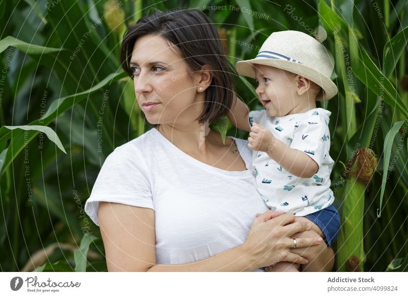 Adorable mother and child on hand enjoying and laughing in field family orchard parent happy fun together kid childhood little day cheerful motherhood joyful