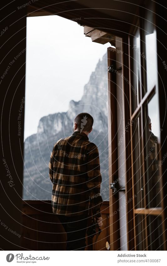 Male in casual wear standing by a window traveler moment inspiration wanderlust tourism nature dolomites mountains italy landscape sightseeing journey