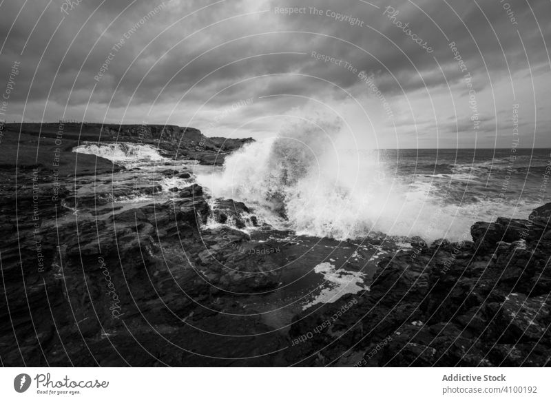 Waves breaking on shore on stormy day wave rock sea ocean power splash crash clouds northern ireland landscape dramatic energy mountain stone water rough nature