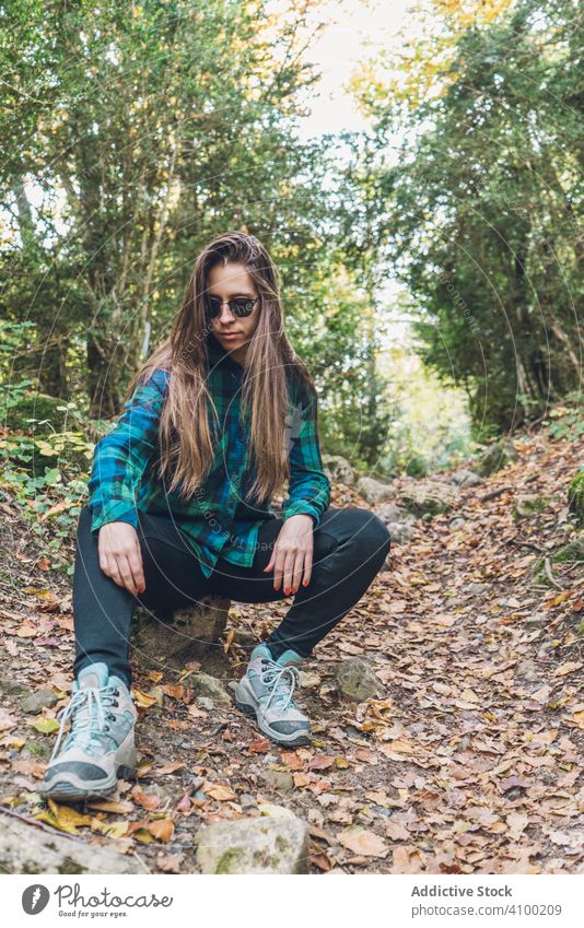 Stylish female teenager in casual outfit at autumn forest woman walking sitting stub stylish trendy fashionable sunglasses plaid shirt sneakers path leaves