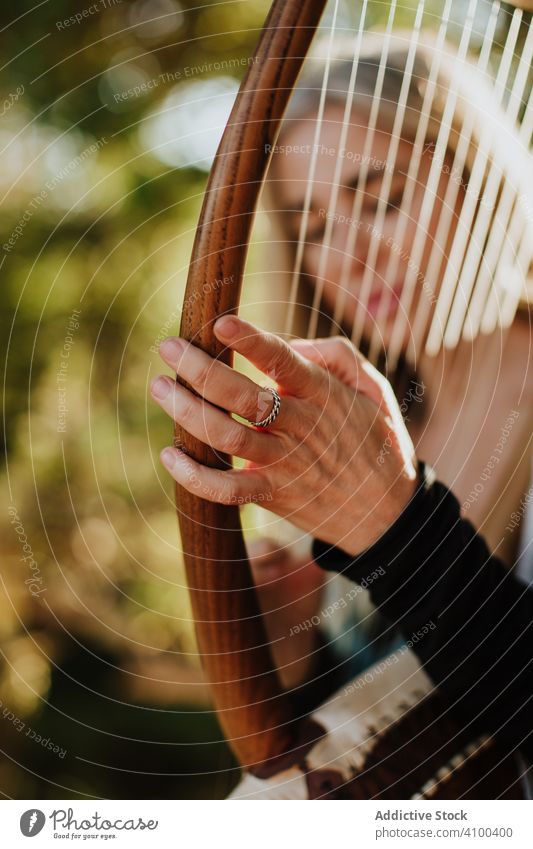 Sensual female musician playing lyre in garden romance woman ballade melody musical instrument talented summer sunny art inspiration muse dream classic