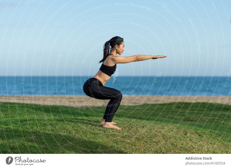 Woman doing yoga on the beach woman practice grass green sea ocean female stand exercise balance training workout young athlete active calm tranquility