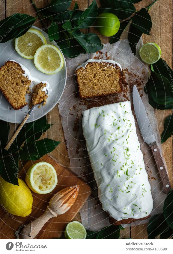 Sweet bread with fresh citruses pastry sweet table kitchen loaf icing lemon lime knife juicer plate spoon frosting piece slice fruit food gourmet dessert