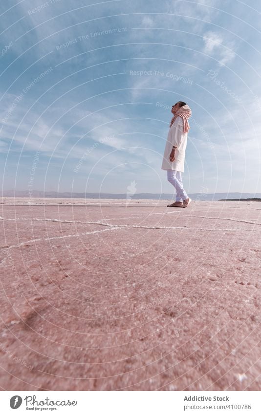 Thoughtful relaxed tourist enjoying unusual scenery of pink salt lake woman dry shore tourism pensive tranquil calm freedom peace coast environment contemplate