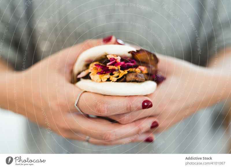 Woman holding Asian snack food steamed bread bun asian traditional sandwich bao hands woman gua bao cuisine chinese taiwanese meal meat vegetables dish female