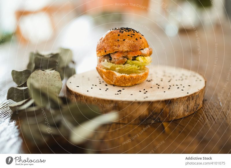 Delicious hamburger with black sesame on wooden tray table round board meal food fast food dinner junk food meat bread tasty lunch delicious eating calorie