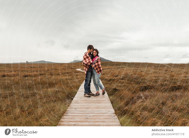 Couple standing on wooden pathway among wetland couple travel scotland peat plaid bog together landscape romantic romance relationship love footpath grass brown