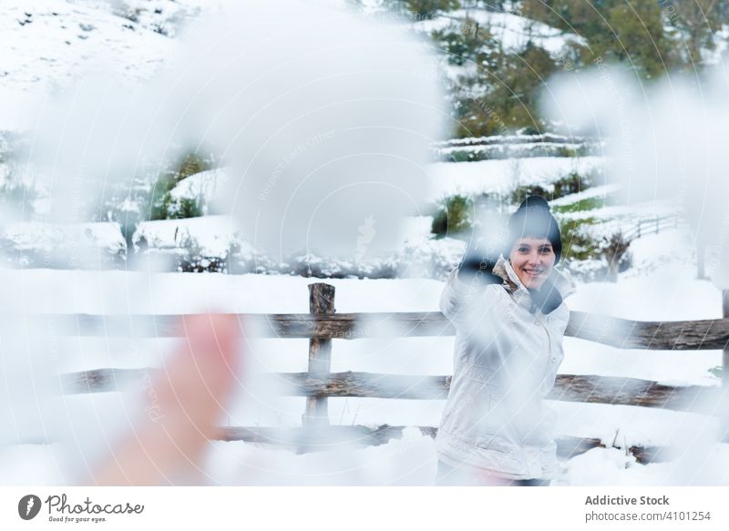 Smiling woman playing with snow in countryside snowball winter smile joy mountain rest resort holiday nature village rural cold fun game vacation tree white