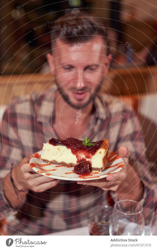 Guy in casual clothing taking slab of cake at restaurant man dessert male food sweet celebration party table birthday festive guy sitting tasty delicious cafe