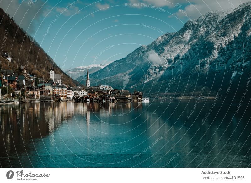 Mountain coast with houses along turquoise lake travel shore reflection mountain landscape nature cloudy crystal hallstatt scenic environment scenery vacation