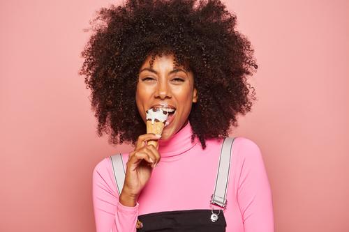 Funny woman with ice cream looking at camera fun happy smeared lips pink laugh cheerful excited eating african american black stand ethnic female young childish