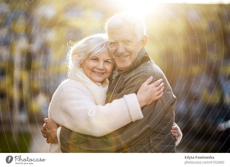 Senior couple hugging outdoors in autumn woman love people together two senior mature pensioners togetherness retiree retired retirement old marriage healthy
