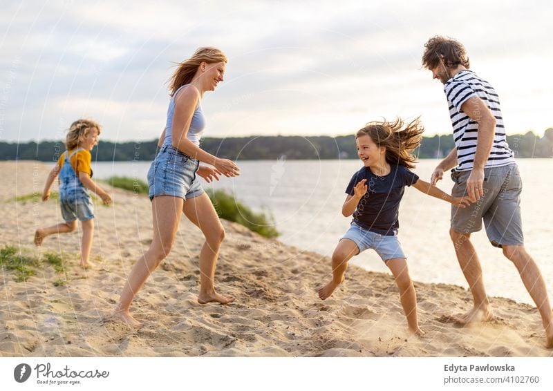 Young family having fun outdoors at the beach Beach Ocean Lake holidays vacation Nature Summer Family Parents Son Boy (child) children Together