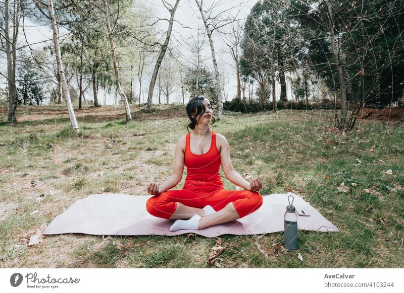 Young woman in fitness clothes doing yoga exercises over a yoga mat at the park during a sunny day person laptop health female outside relax training slim sport