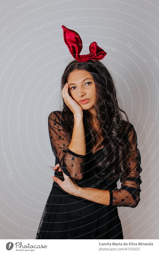 Young woman with black dress and red bow in her hair. Fashion photography. Autumn / winter fashion. Hair accessory. beautiful beauty blogger elegance face