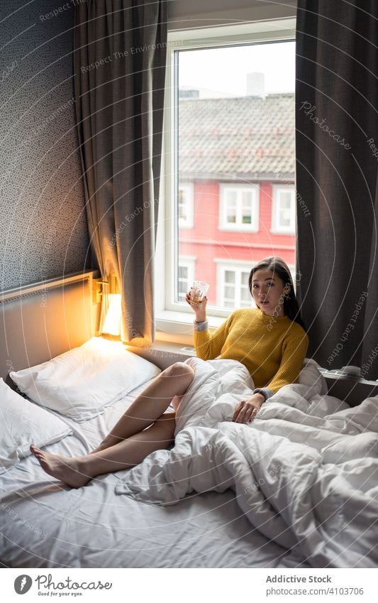 Female drinking tea in morning woman bed sitting looking window view sweater coffee cup home female relax breakfast beverage mug hot lifestyle casual cold