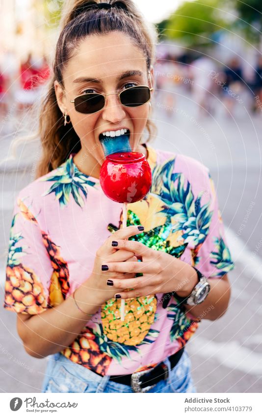 Cheerful lady having fun enjoying sweet candy apple woman fair relax snack trendy cool happy holiday v sign amusement bright carnival summer colorful vacation