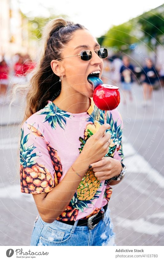 Cheerful lady having fun enjoying sweet candy apple woman fair relax snack trendy cool happy holiday v sign amusement bright carnival summer colorful vacation
